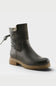 A dark gray leather ankle boot with a textured gray elastic side panel, a gray knit collar, and a brown lug sole, shown on a light gray background.