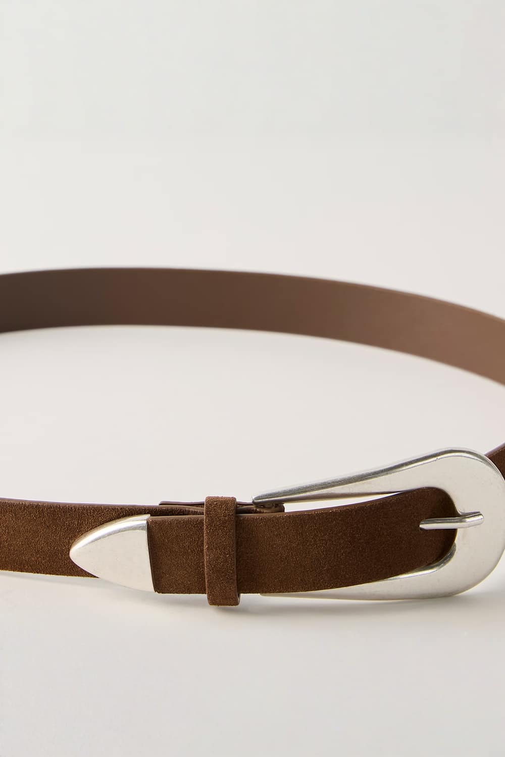 A close-up of a brown leather belt with a silver-tone metal buckle, shown on a clean white background.