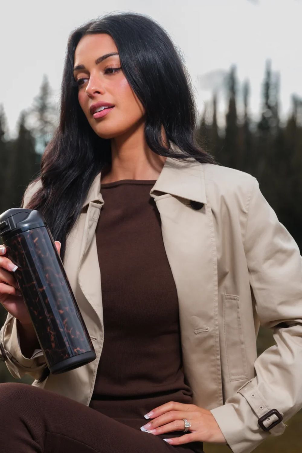 model with A tall, cylindrical insulated bottle with a black lid and a dark tortoiseshell pattern body