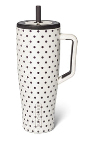 A tall white travel mug with a black polka dot pattern, featuring a white handle, a black lid, and a black straw, shown on a white background.
