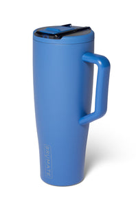 A matte blue insulated travel tumbler with a matching blue handle and lid, featuring a black straw insert and the BRUMATE brand name printed vertically near the base, set against a plain white background.