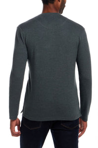A man viewed from the back wearing a dark heather gray long-sleeve shirt and dark blue jeans against a plain white background.