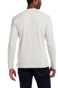 A man viewed from the back wearing a light heather gray long-sleeve crewneck shirt and dark blue jeans, set against a plain white background.