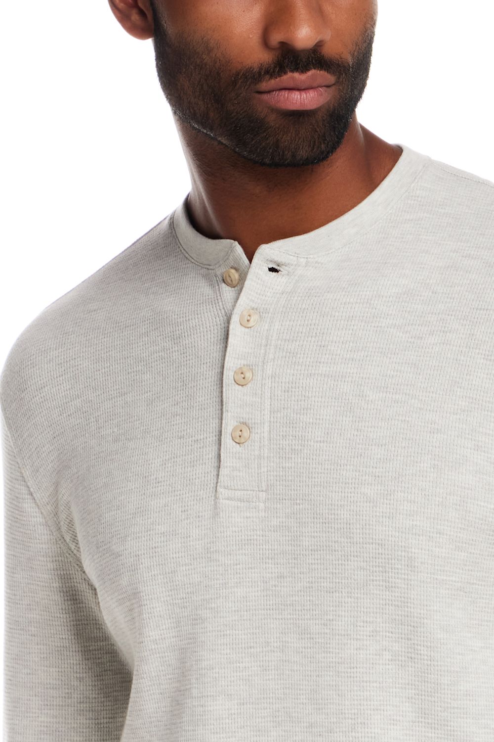 Close-up of a man wearing a light heather gray ribbed henley shirt with a three-button placket.