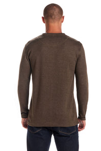 A man viewed from the back wearing a dark brown long-sleeve crewneck shirt and dark blue jeans against a white background.