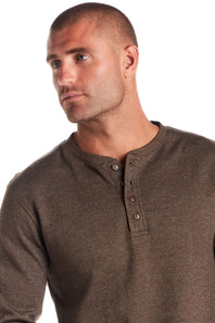 A man wearing a brown ribbed Henley shirt, shown from the chest up against a plain white background.