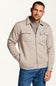 A man wearing a light beige zip-up fleece jacket over a gray t-shirt and blue jeans, photographed against a clean white studio background.