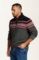 A man wearing a dark gray quarter-zip sweater with a black yoke and a red, white, and gray Fair Isle pattern across the chest, paired with blue jeans, photographed against a plain off-white background.
