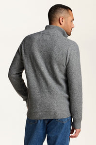 A man wearing a gray knit quarte zip sweater, shown from the back and side profile against a plain off-white background.