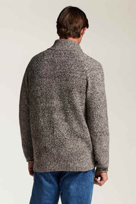 A man viewed from behind wearing a textured gray and black marled knit sweater with a mock neck, paired with blue jeans, against a plain light background.