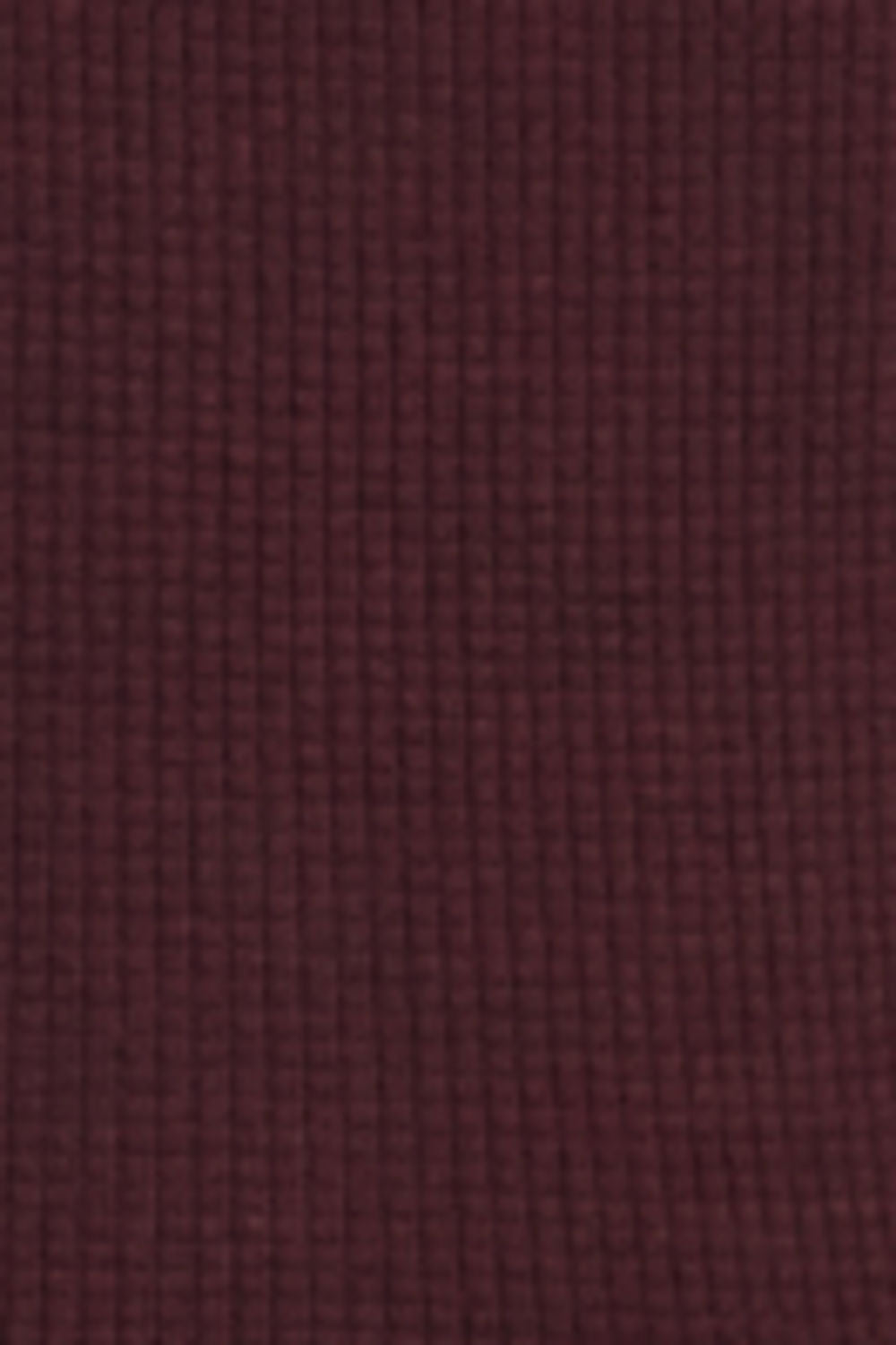 A close-up of a textured fabric swatch in a deep burgundy or maroon color, showing a fine waffle or grid-like weave pattern.