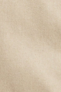 A close-up texture shot of a soft, warm beige fabric with a fine, slightly mottled weave.