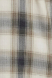 A close-up of a plaid fabric pattern with a cream base and intersecting brown, gray, and dark charcoal stripes.
