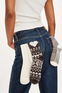 Person holding three pairs of patterned socks against a white background