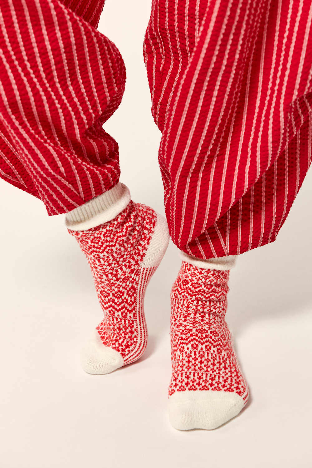 Red and white striped pants with matching socks on a light background