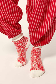 Red and white striped pants with matching socks on a light background