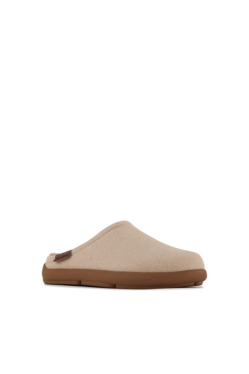 A single slip-on clog-style mule shoe in light beige suede or fabric with a brown sole, shown from the side against a plain white background.
