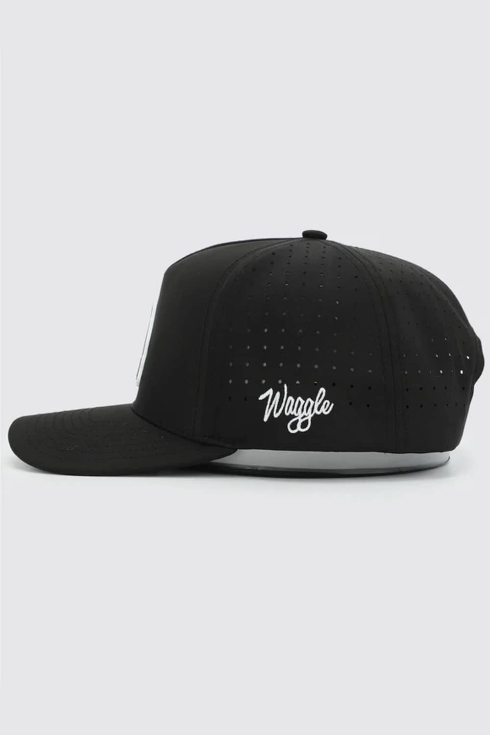 A black flat-brim baseball cap with a white script logo reading 'Waggle' on the side, shown against a light gray background.