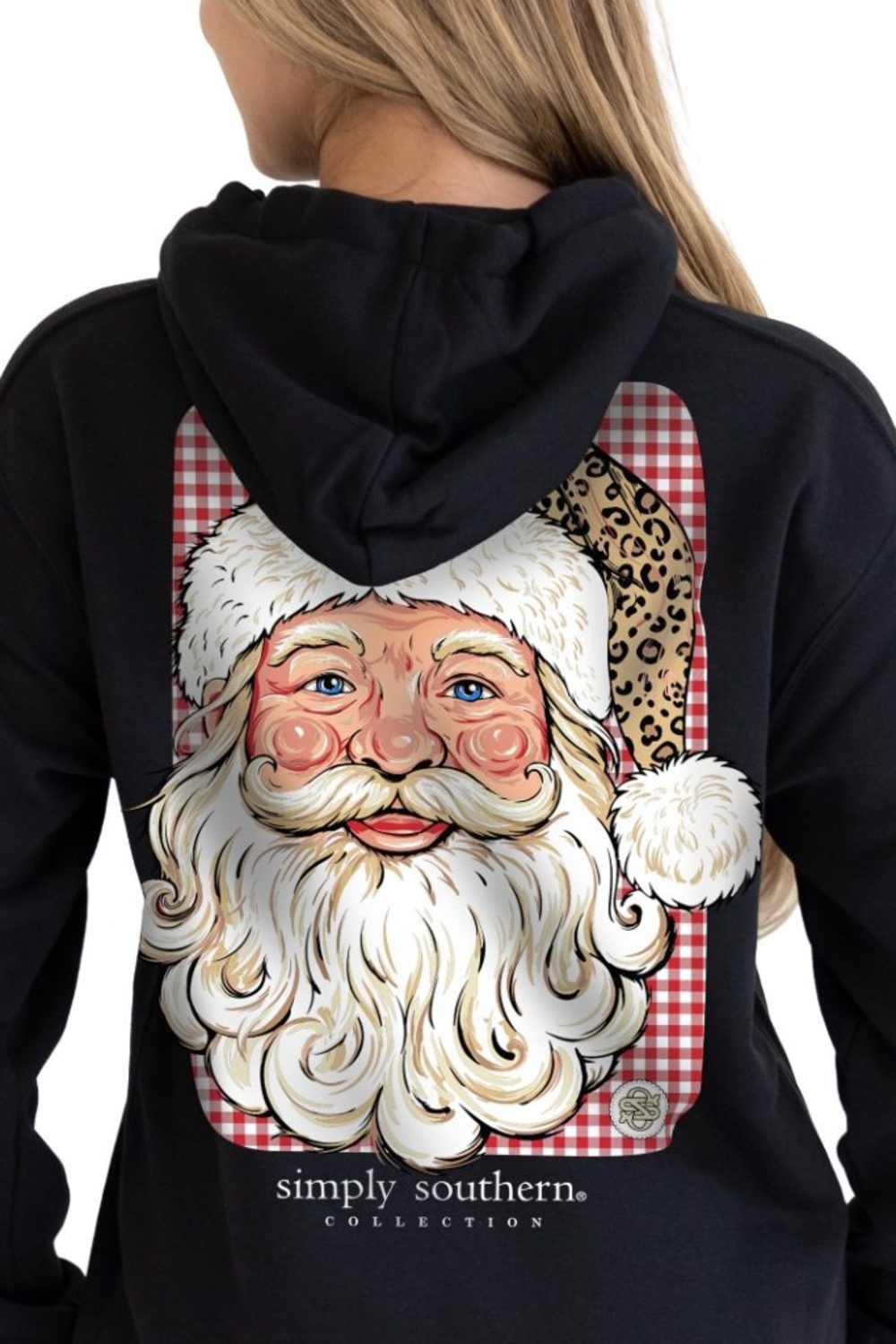 A woman wearing a black hoodie from the back, featuring a large graphic print of Santa Claus with a white beard, red and white gingham background, and a leopard print accent on the hat. The brand name 'simply southern collection' is printed below the graphic.