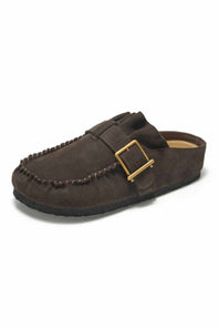 A dark brown suede moccasin-style clog shoe with a decorative strap and a gold-tone buckle, shown from a side angle on a white background.