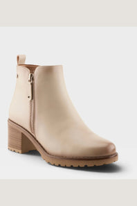 A beige leather ankle boot with a side zipper, chunky block heel, and lug sole, shown against a light gray background.