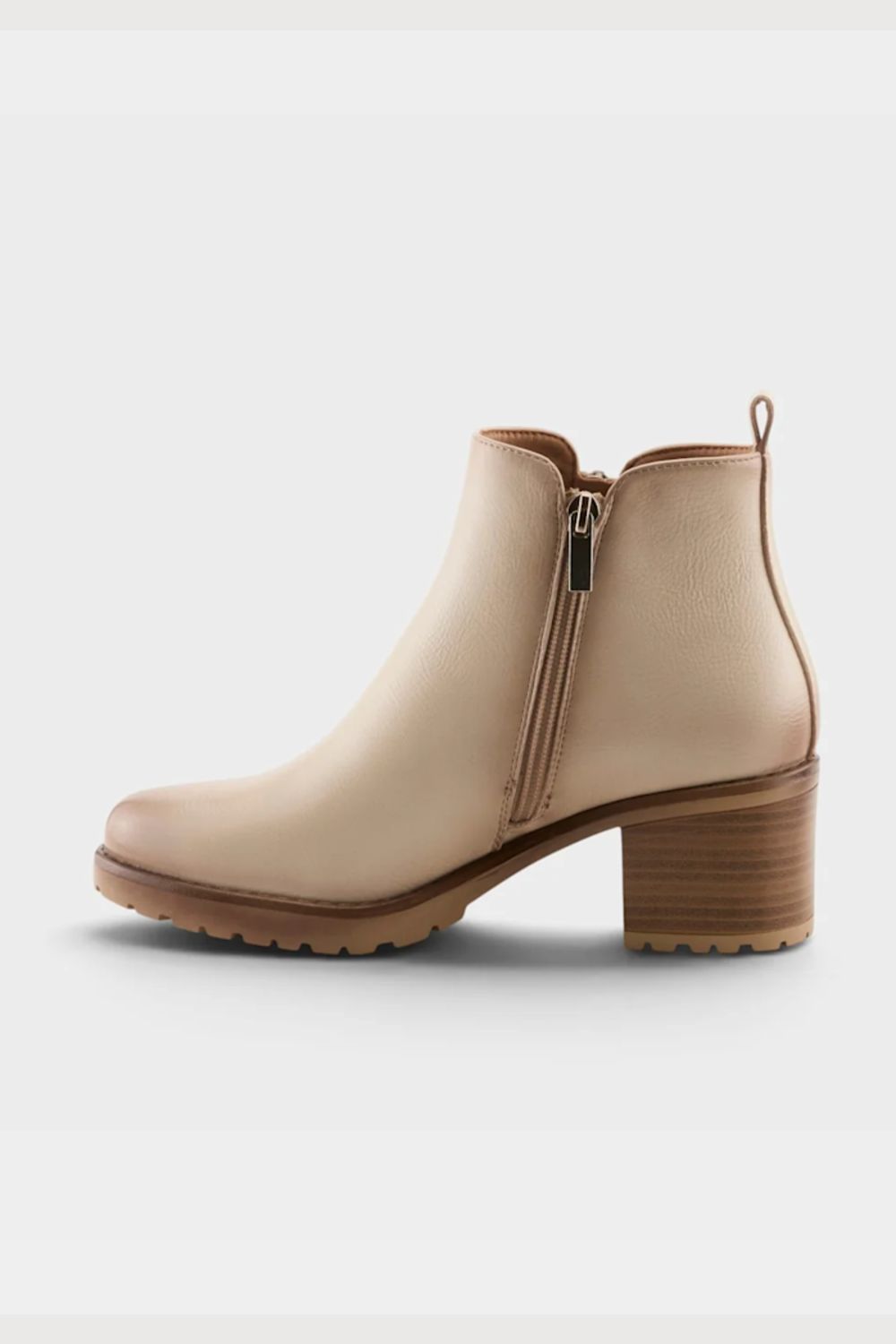 A beige ankle boot with a side zipper, low block heel, and chunky lug sole, shown from a side profile on a light gray background.