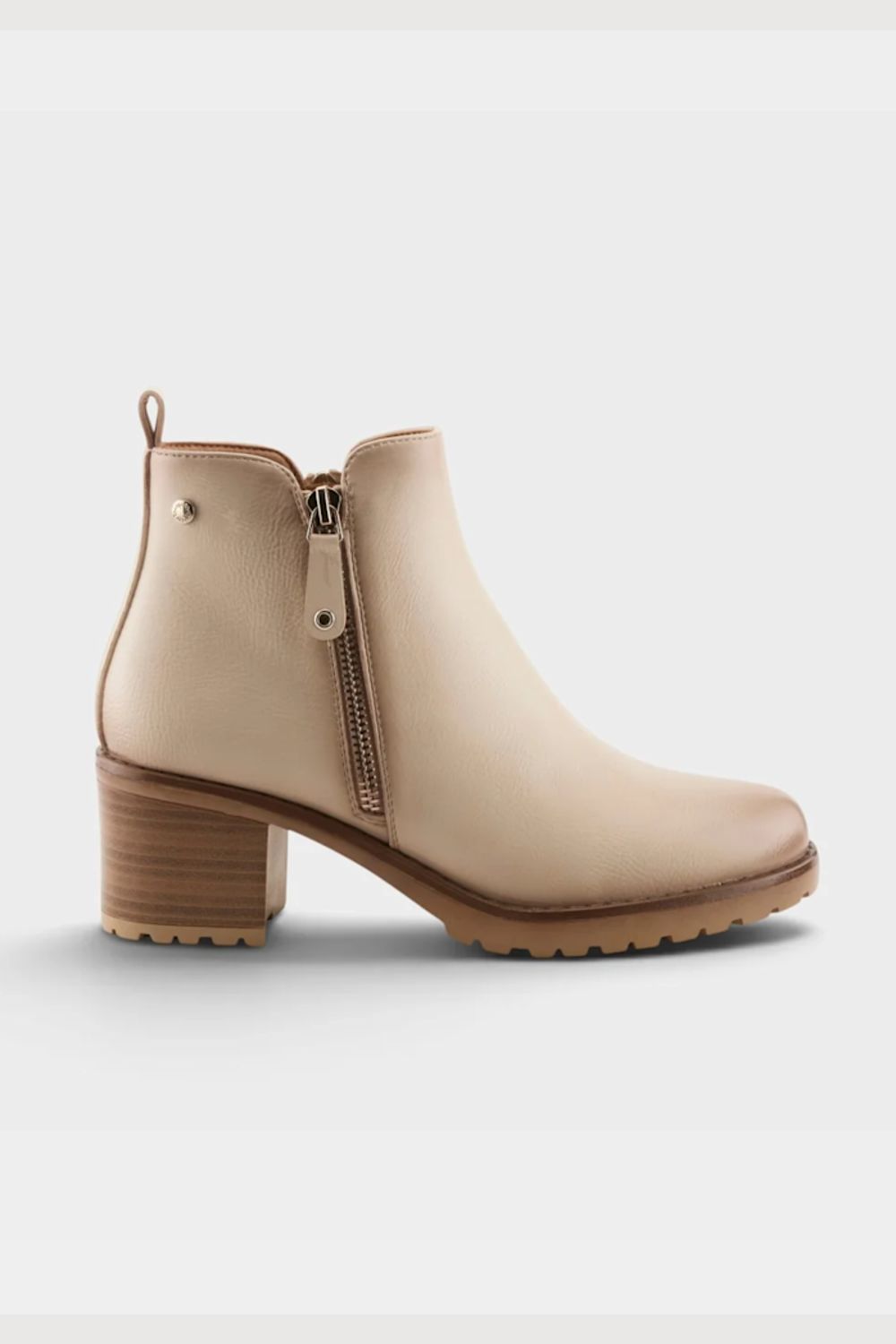 A light beige ankle boot with a side zipper, block heel, and textured sole, shown from a side profile on a light gray background.
