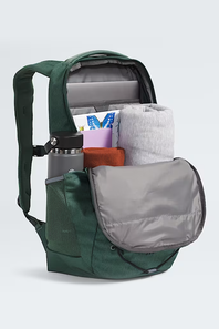Green backpack with compartments filled with items on a light gray background