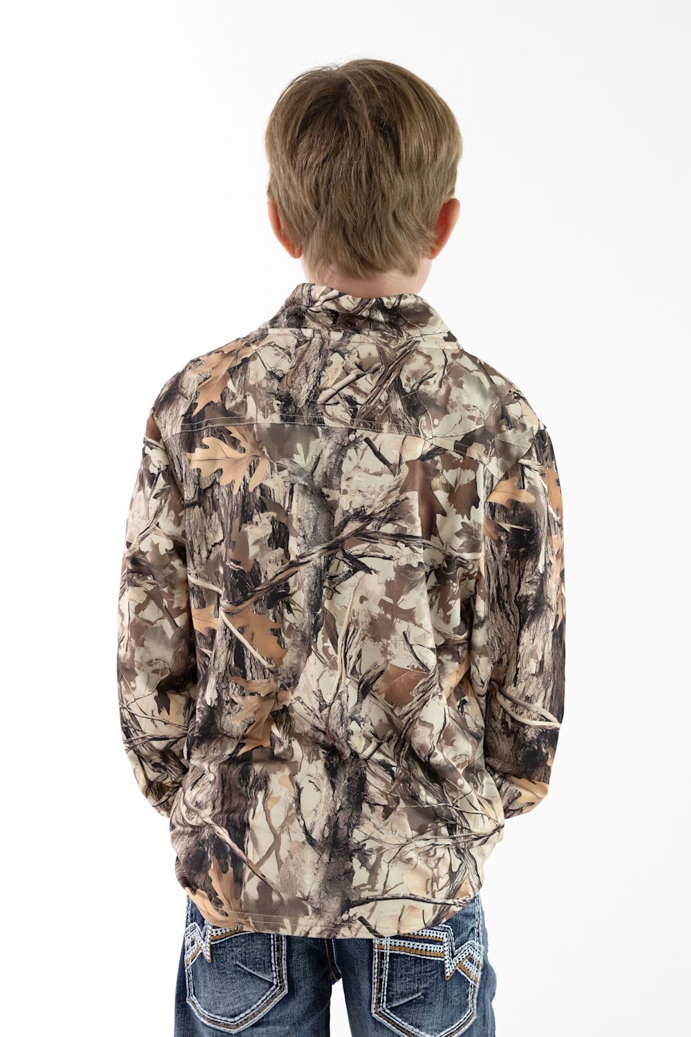 Back view of a young boy with short blonde hair facing away from the camera, wearing a long-sleeve quarter-zip pullover in Leaf Camo paired with blue jeans featuring stitching on the back pockets against a solid white background.