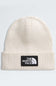 An off-white ribbed knit beanie hat featuring a black rectangular patch on the front with the white 'THE NORTH FACE' logo.