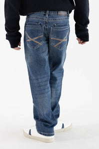 Rear view of a boy wearing Axel Jeans medium-wash straight-leg denim featuring cross-stitched tan embroidery on the back pockets, styled with white sneakers.