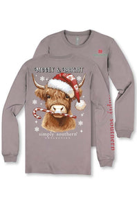 A long-sleeve crewneck t-shirt in a muted mauve-gray color, featuring a festive graphic of a Highland cow wearing a Santa hat and candy cane, with 'MOOEY & BRIGHT' and 'simply southern' text. A second view of the shirt is shown behind it to display the red vertical 'simply southern' branding on the sleeve.