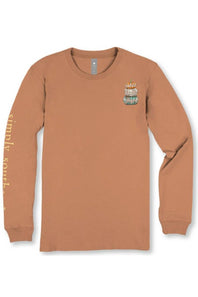 A long-sleeve crewneck t-shirt in a warm terracotta or rust color, featuring a small multicolor graphic on the left chest and 'simply so.