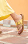Yellow sandal worn on a foot with a blurred background