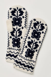 A pair of knit fingerless mittens with a dark navy blue Fair Isle pattern on an off-white background, displayed against a light neutral background.