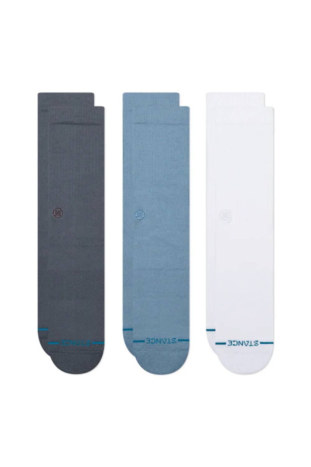 Three pairs of Stance crew socks in dark gray, dusty blue, and white, arranged side-by-side on a plain white background.
