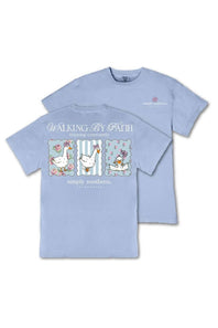 A light blue short-sleeve t-shirt with a graphic on the back showing three cartoon-style goose illustrations in pastel colors, with the text 'WALKING BY FAITH' and 'simply southern, SC' printed below. A smaller version of the logo is visible on the left chest.