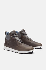 A pair of mid-top lace-up sneakers in a dark brownish-gray leather, featuring gray laces, a white midsole, and a light blue interior lining, shown against a light gray background.