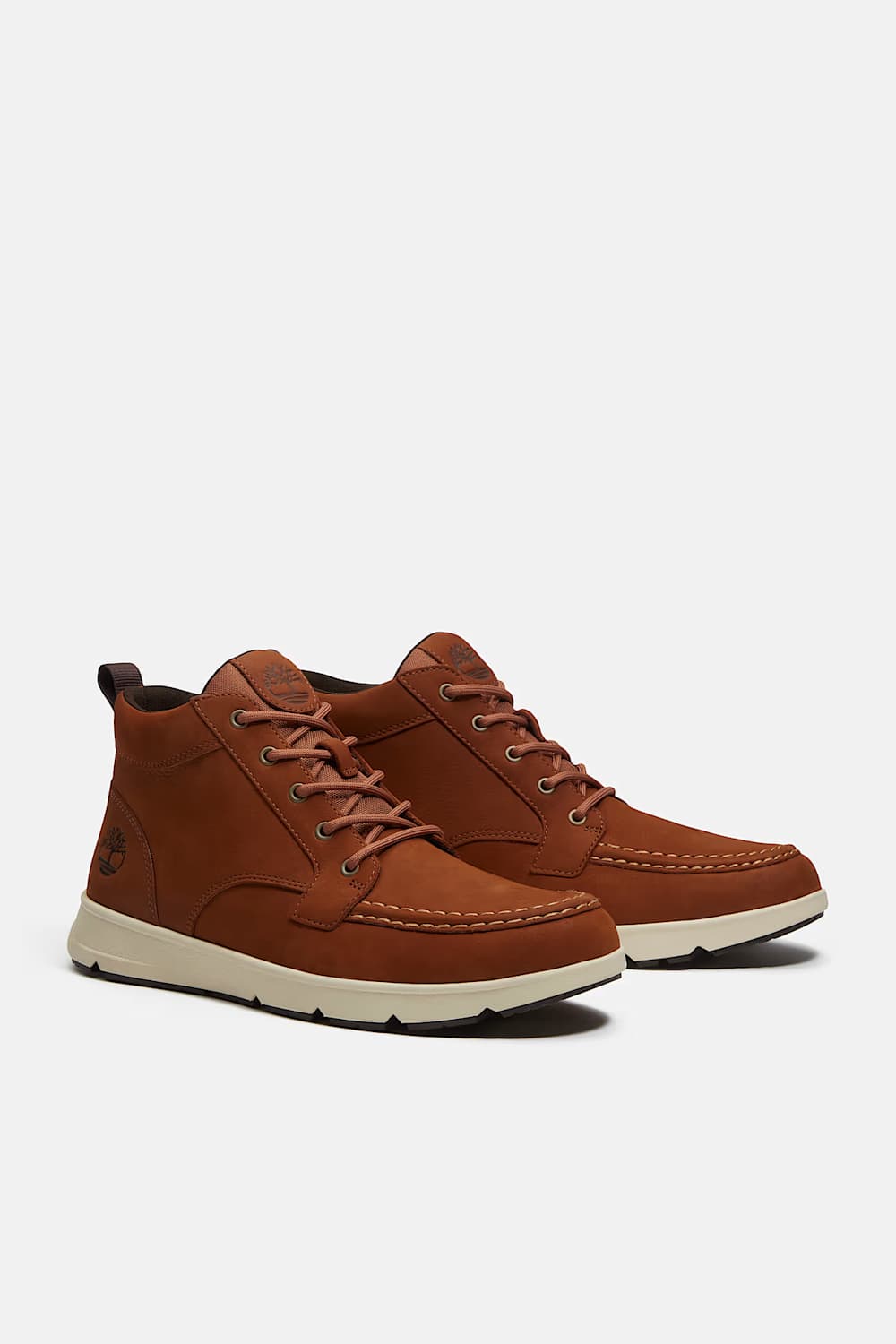 A pair of brown suede Timberland sneakers with white soles, displayed against a light gray background.