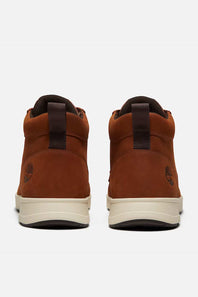 A pair of Timberland mid-top boots in brown suede, shown from the back against a light gray background.