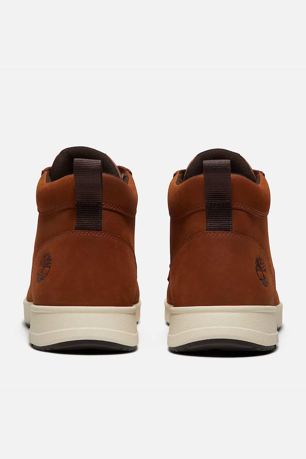 A pair of Timberland mid-top boots in brown suede, shown from the back against a light gray background.