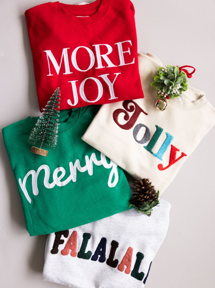 Holiday fleece sweatshirts with festive decorations.