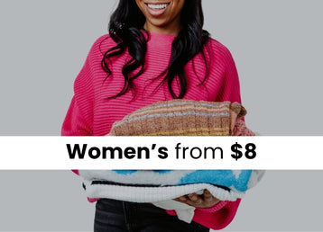 A woman wearing a hot pink ribbed knit sweater holding a stack of different sweaters. The image has a dark overlay with a white stripe in the image with text that reads Women's from $8