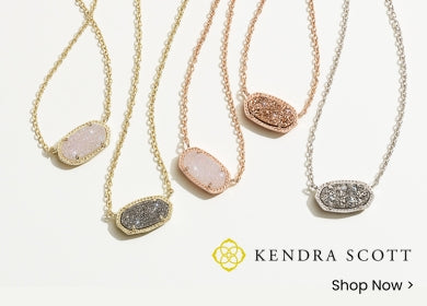 Five different colors of Kendra Scott necklaces on a plain studio background with the Kendra Scott logo and a Shop Now call-to-action in the bottom right corner