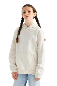 A young girl with braided hair wearing a cream-colored pullover hoodie and light blue jeans, standing against a solid white background.