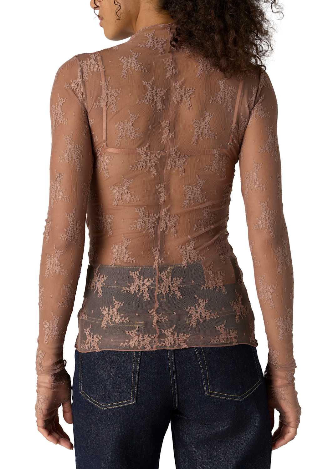 A woman shown from the back wearing a sheer brown long-sleeve top with a tonal floral lace pattern and dark blue jeans against a white background.