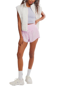 FP Movement Carpe Diem Shorts for Women in Powder Pink; Person wearing a white vest, light purple shorts, and white sneakers on a white background