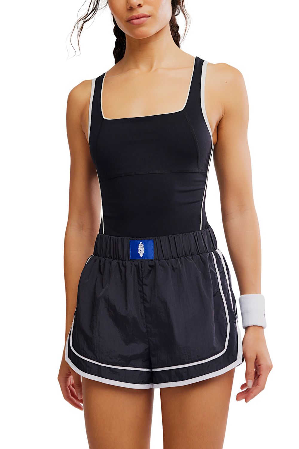 FP Movement Varsity Blues Runsie for Women in Black Combo; Woman wearing a black athletic set with a blue logo on a white background