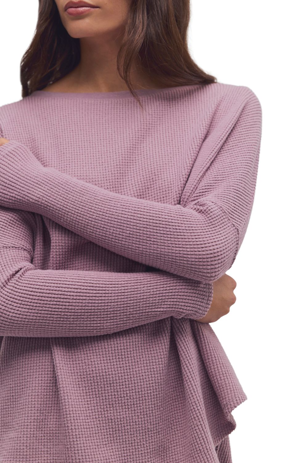A close-up of a woman wearing a dusty mauve waffle-knit long-sleeve top with a boat neckline, shown against a plain white background.