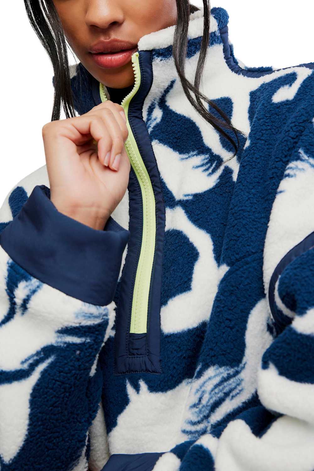 Close-up shot of the FP Movement Printed Mountain High 1/2 Zip Fleece featuring a navy and white abstract horse print, a high stand-up collar with a neon yellow front zipper, and navy trim along the cuffs and collar.